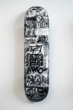 a skateboard covered in graffiti sitting on top of a wall