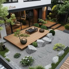 an outdoor area with rocks and plants on the ground, surrounded by wooden decking