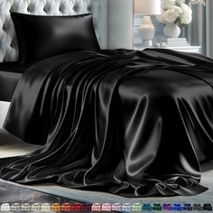 a bed with black sheets and pillows on it