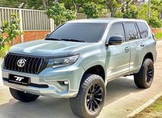 a silver suv parked on the side of a road