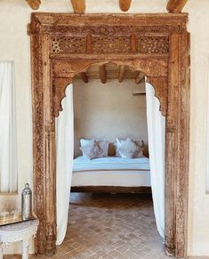 a bed sitting under a wooden canopy in a bedroom