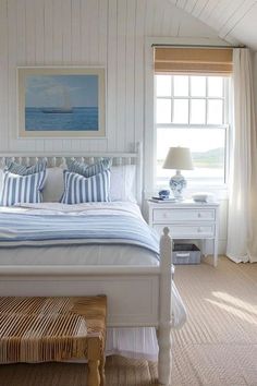 a white bed sitting under a window in a bedroom