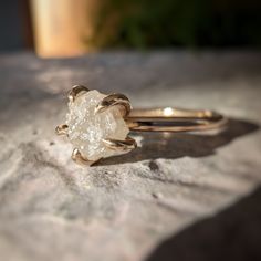 a white diamond ring sitting on top of a rock