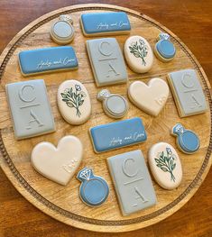 cookies decorated with blue and white icing are arranged on a wooden platter that reads,