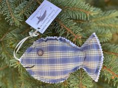 a blue and white fish ornament hanging from a christmas tree with a tag on it