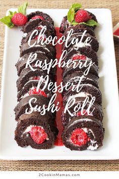 chocolate raspberry desert rolls on a white plate with strawberries and mint leaves