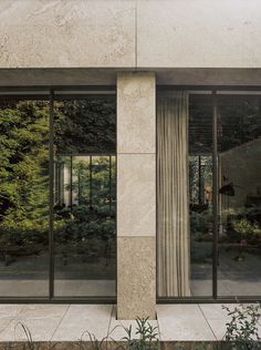 an outside view of a building with glass doors and trees in the backround