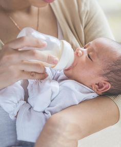 a woman feeding a baby with a bottle