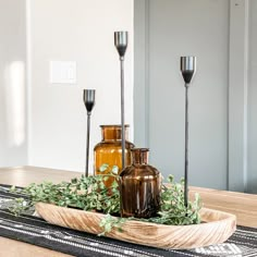 vases and candles are arranged on a tray