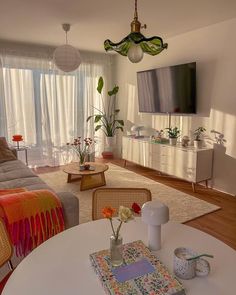 a living room filled with furniture and a flat screen tv mounted to the side of a wall