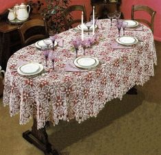 the table is set with white plates and silverware on it, along with pink walls