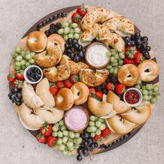 a platter filled with different types of breads, fruit and dipping sauces