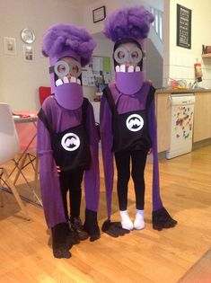 two people in purple costumes standing next to each other on a hard wood floored room floor