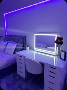 a white desk with a mirror and some drawers in a purple lit up bedroom area