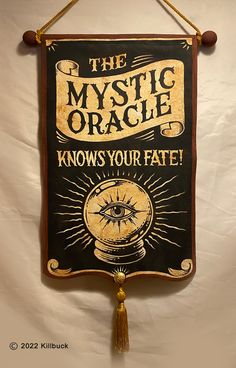 the mystic oracle knows your fate sign hanging from a rope with tassels on it