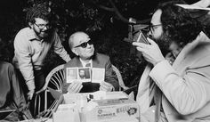 black and white photograph of three men sitting around a table