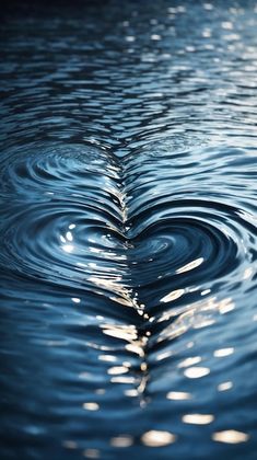 a heart shaped wave in the water with sunlight reflecting off it's surface and creating ripples