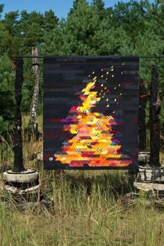 a painting is displayed in the grass near trees