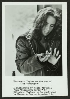 a black and white photo of a woman looking at her cell phone