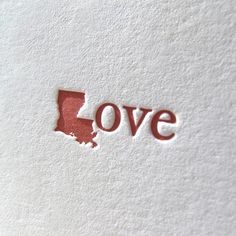 the word love is written in red on a white paper with a state shaped outline