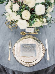 the table is set with silverware and flowers