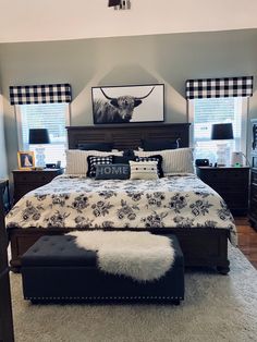 a bedroom with a cow head on the wall above the bed and ottoman underneath it