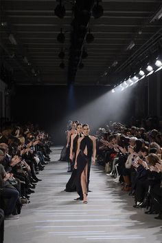 black and white photo of two women walking down the runway