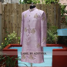 a mannequin is dressed in a purple outfit with gold embroiderys on it