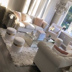 a living room filled with white furniture and lots of windows