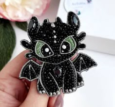 a black dragon brooch with green eyes