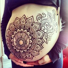 a pregnant woman's belly with an intricate design on it