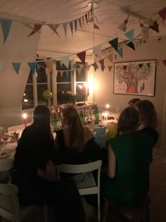 several people sitting at a table with candles