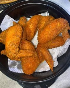 fried chicken wings in a black bowl on a table