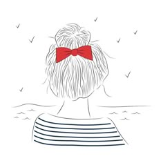 a woman with a red bow on her head looking out over the ocean at birds