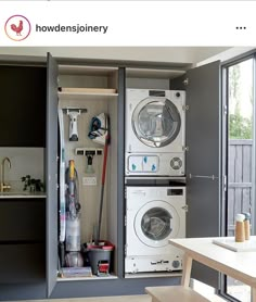 a washer and dryer are in an open cabinet next to the kitchen table