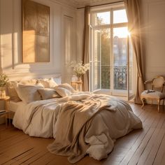 the sun shines brightly through the window onto a bed in a bedroom with white walls and wood flooring