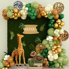 an animal themed birthday party with balloons and jungle animals on the front wall, zebras in the background