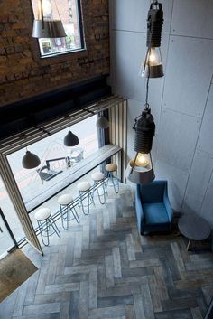 an overhead view of a restaurant with blue chairs and lights hanging from the ceiling above