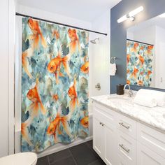 a bathroom with a shower curtain that has goldfish on it, and a toilet in the background