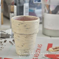 a white vase sitting on top of a table