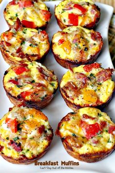 several breakfast muffins are arranged on a white platter, ready to be eaten