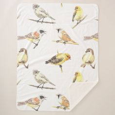 a white blanket with birds on it and a yellow bird sitting on the back of it