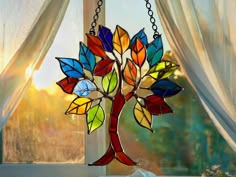 a stained glass tree hanging from a window