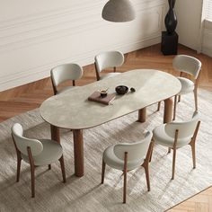 a dining table with six chairs and a book on it in a room next to a lamp