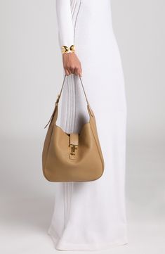 Signature T-shaped hardware adds a heritage touch to this slouchy hobo bag masterfully crafted in Italy from beautifully grained calfskin leather. Hook-tab closure Shoulder strap Leather Made in Italy Designer Handbags Timeless Hobo Bag With Gold-tone Hardware For Office, Timeless Hobo Bag With Gold-tone Hardware For Work, Classic Hobo Bag With Metal Hardware For Formal Occasions, Classic Formal Hobo Bag With Metal Hardware, Timeless Hobo Bag With Gold-tone Hardware, Timeless Formal Hobo Bag With Gold-tone Hardware, Luxury Everyday Soft Leather Hobo Bag, Classic Hobo Bag With Palladium Hardware For Work, Timeless Hobo Bag With Smooth Grain