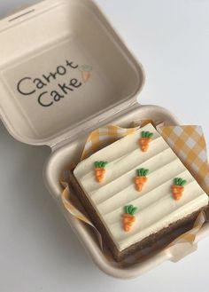 a cake in a container with carrots on it