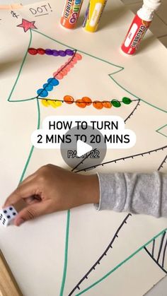 a child is drawing on a paper with crayons and glues to make a christmas tree