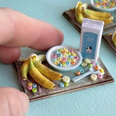 a person is playing with toy food and bananas on the table next to other toys