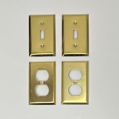 three light switches and two outlet covers on a white surface