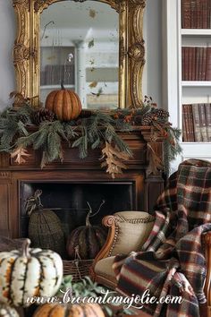 a living room filled with furniture and a fire place covered in pumpkins next to a mirror